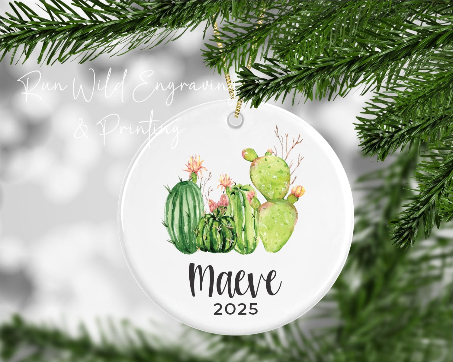 Ceramic Christmas ornament with cactus design and 'Maeve 2025' text, hanging on a tree.