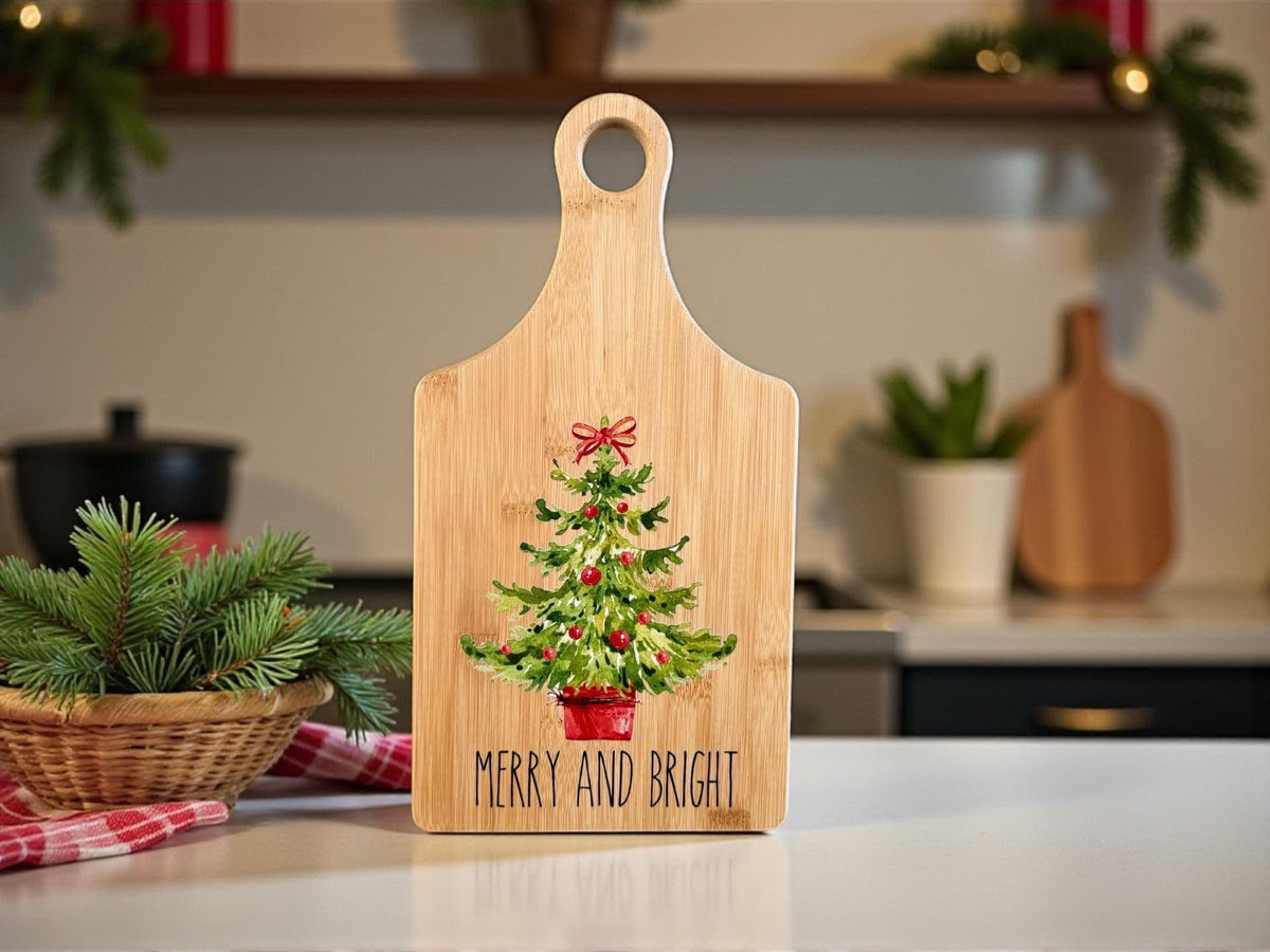 Decorative bamboo paddle board with festive Christmas design and the words “Merry and Bright”.