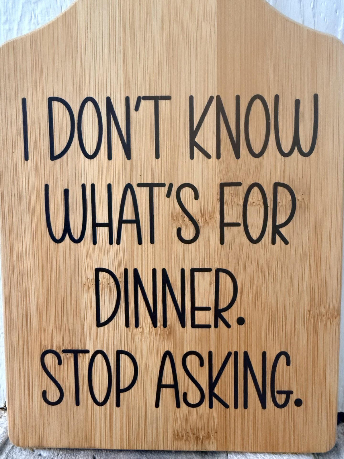 Decorative bamboo paddle board with humorous lettering and the words “I Don't Know What's for Dinner, Stop Asking”.