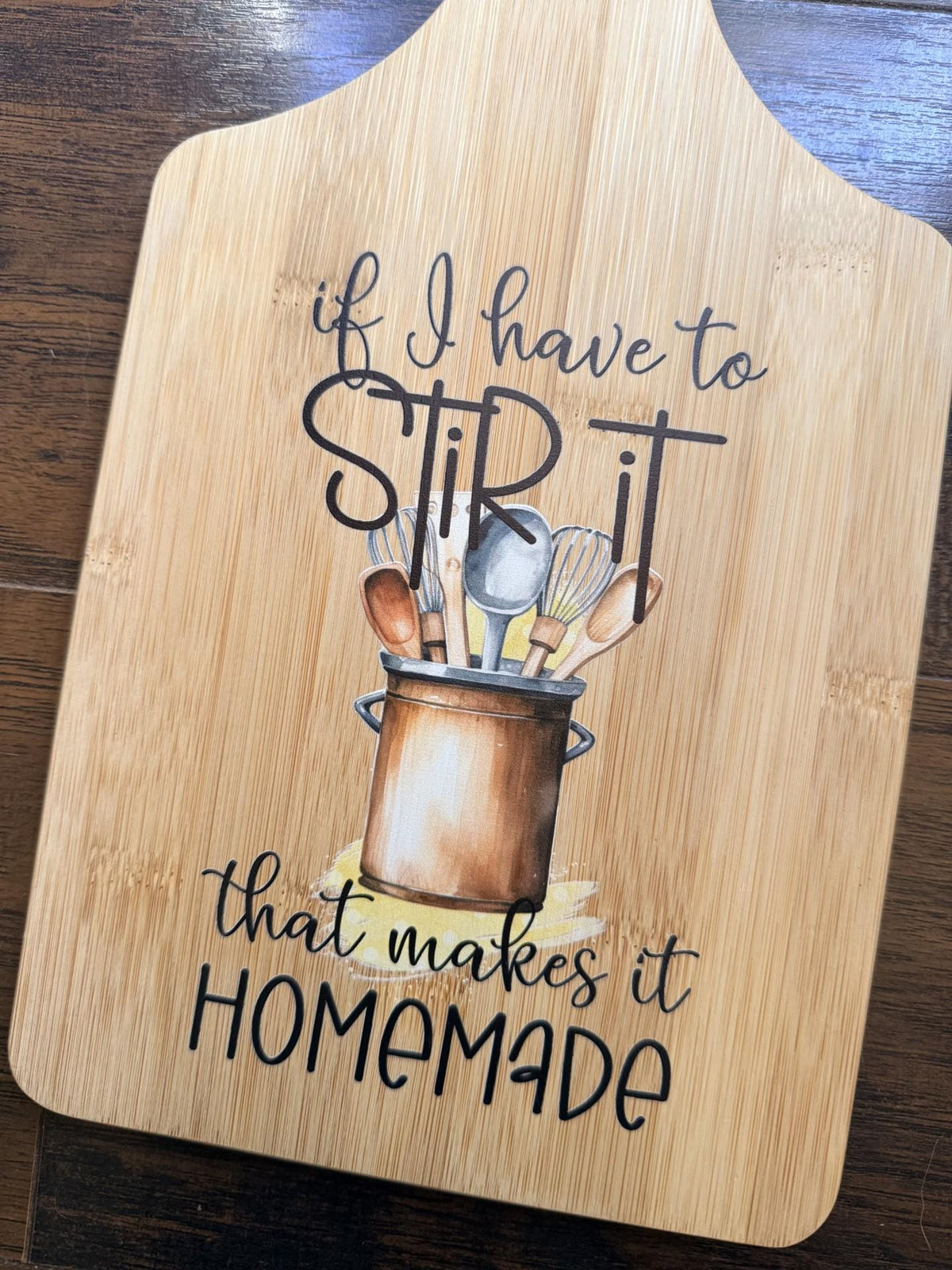 Decorative bamboo paddle board with humorous lettering and the words “If I Have to Stir It, That Makes It Homemade”.