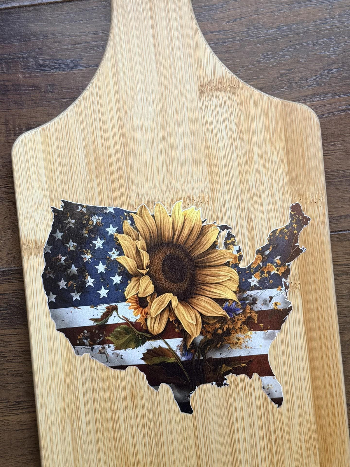 Decorative bamboo paddle board with American flag and sunflower.