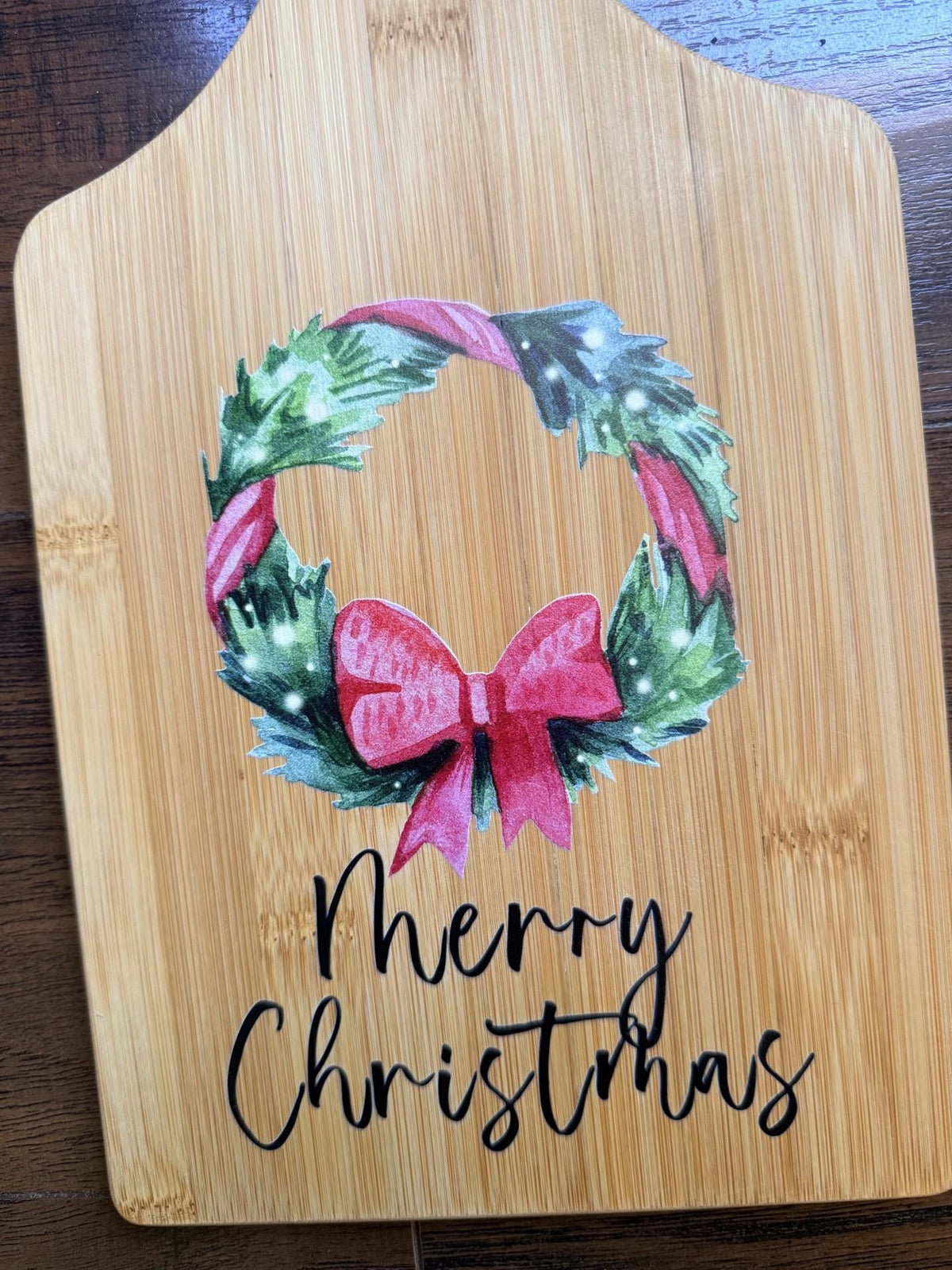 Decorative bamboo paddle board with Christmas design and the words “Merry Christmas”.