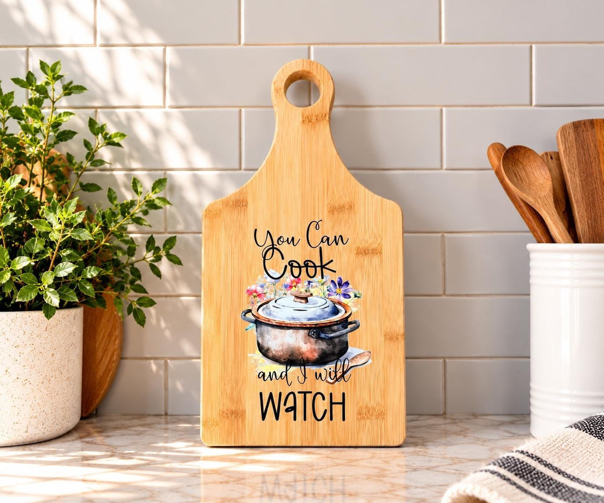 Decorative bamboo paddle board with humorous lettering and the words “You Can Cook and I Will Watch”.