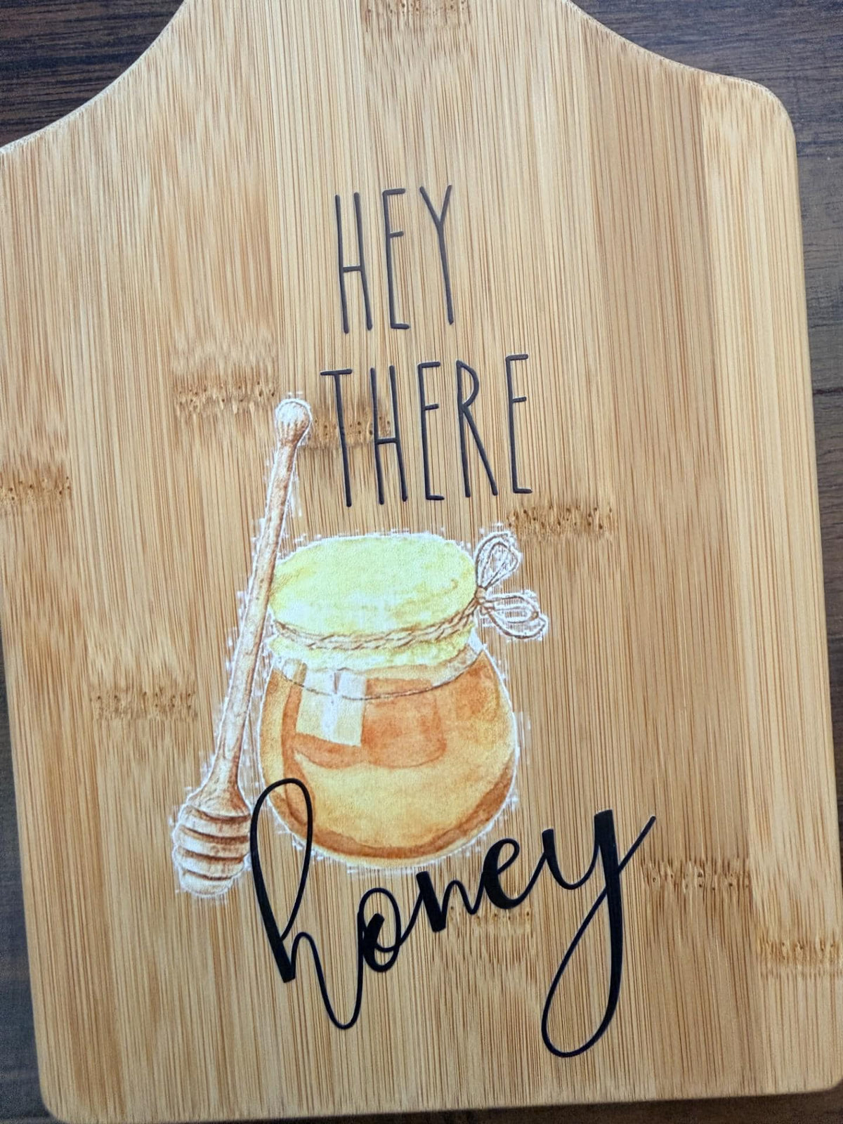 Decorative bamboo paddle board with honey bee illustration and the words “Hey There Honey”.