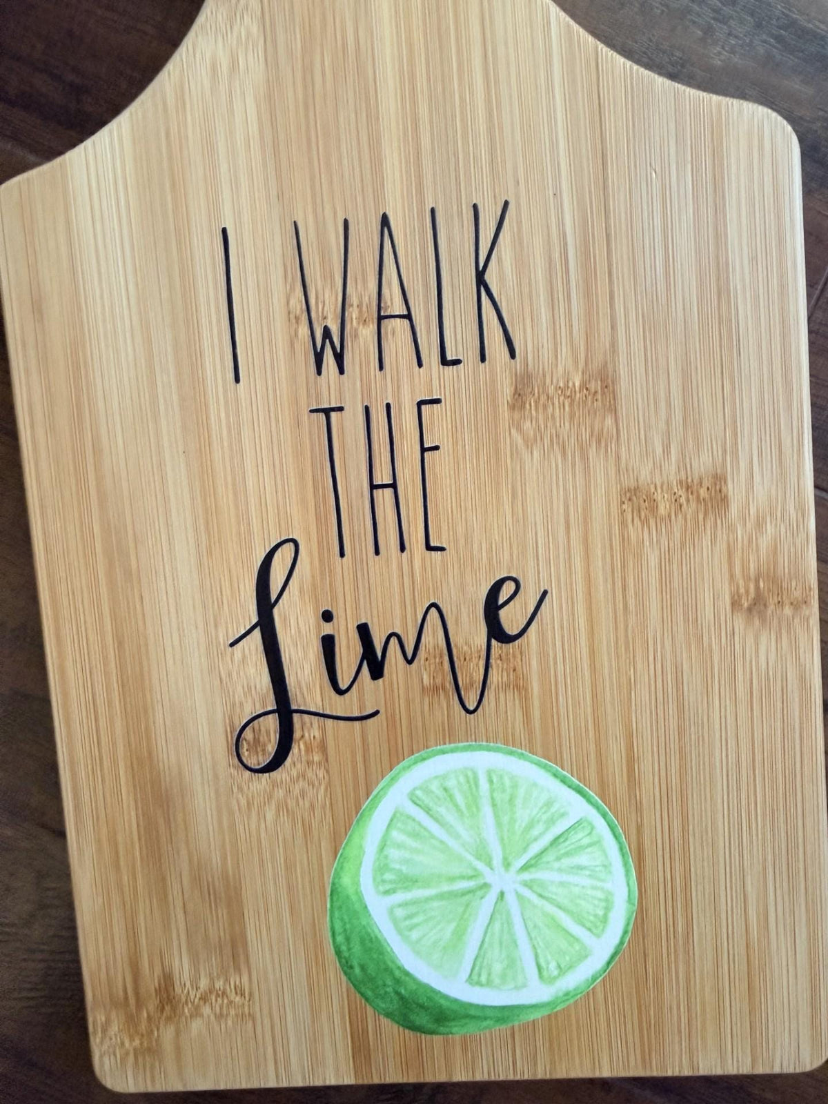 Decorative bamboo paddle board with lime illustration and the words “I Walk the Lime”.