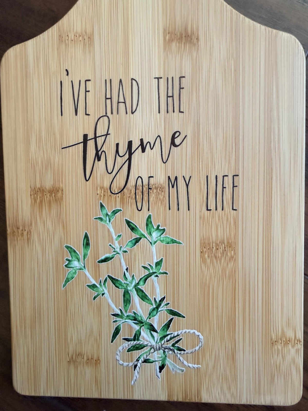 Decorative bamboo paddle board with thyme herb sprig and the words “I've Had the Thyme of My Life”.