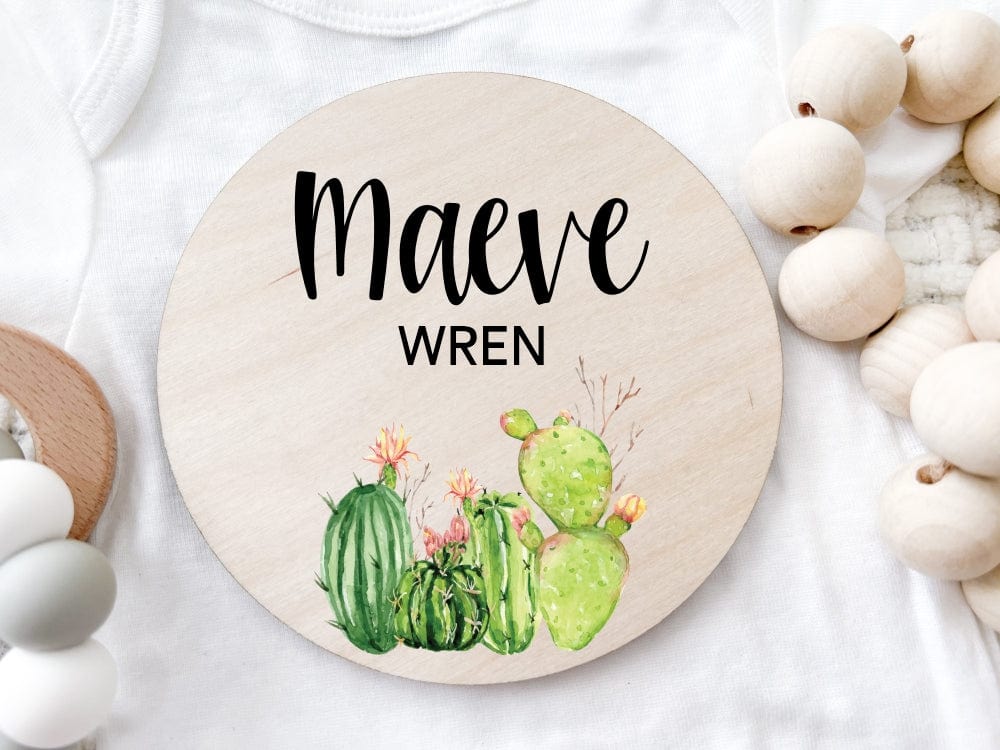 round wood baby name sign printed with baby's first and middle names with cactus design