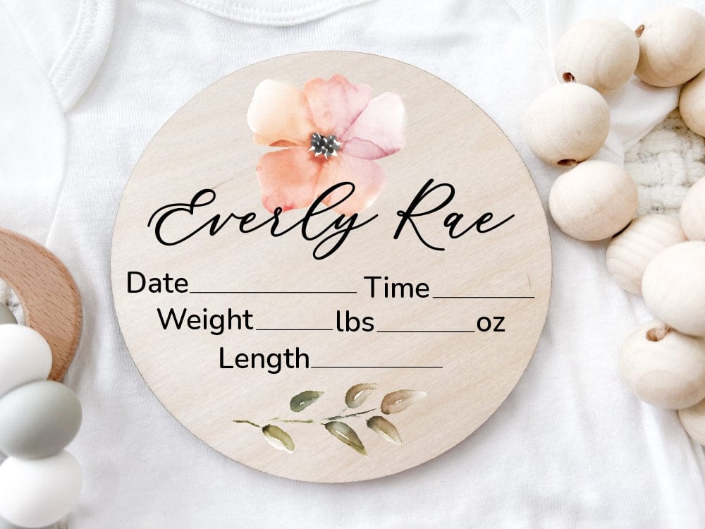 round wood baby name sign printed with watercolor flower, greenery, baby name and birth stats info that can be wrote in