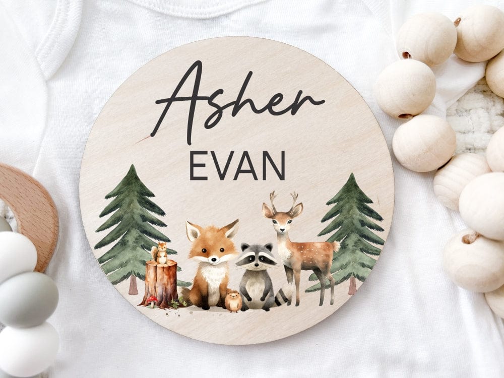round wood baby name sign with woodland theme, including two trees, forest animals such as a fox, deer and raccoon personalized with baby name