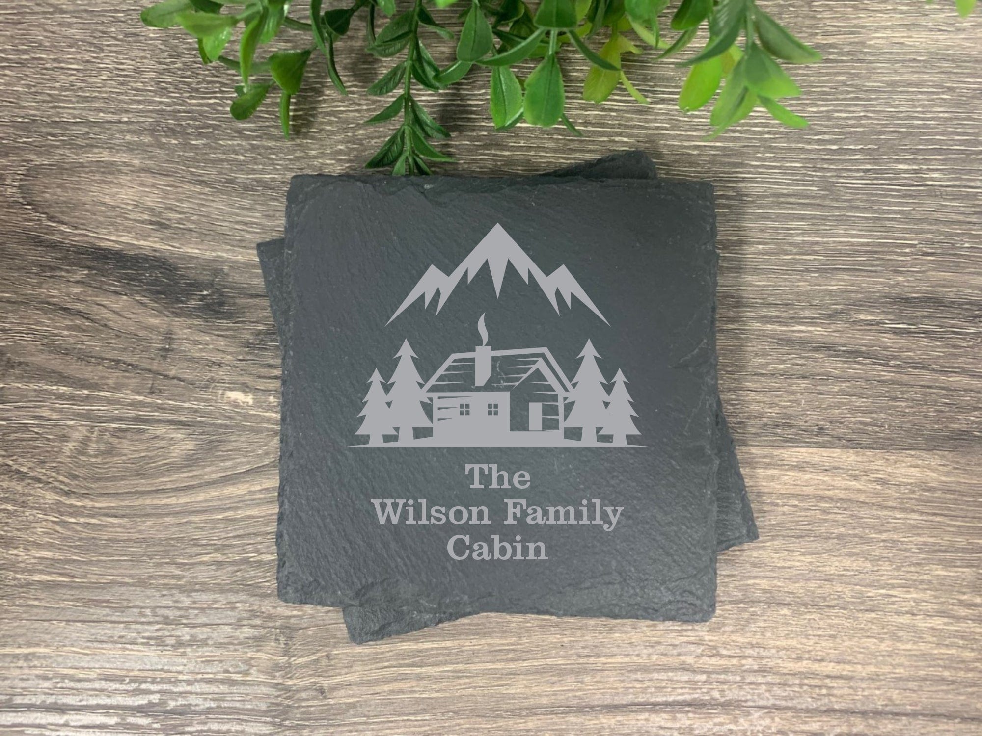 slate coasters engraved with mountain design, cabin and trees personalized with the wording: The (your last name) family cabin