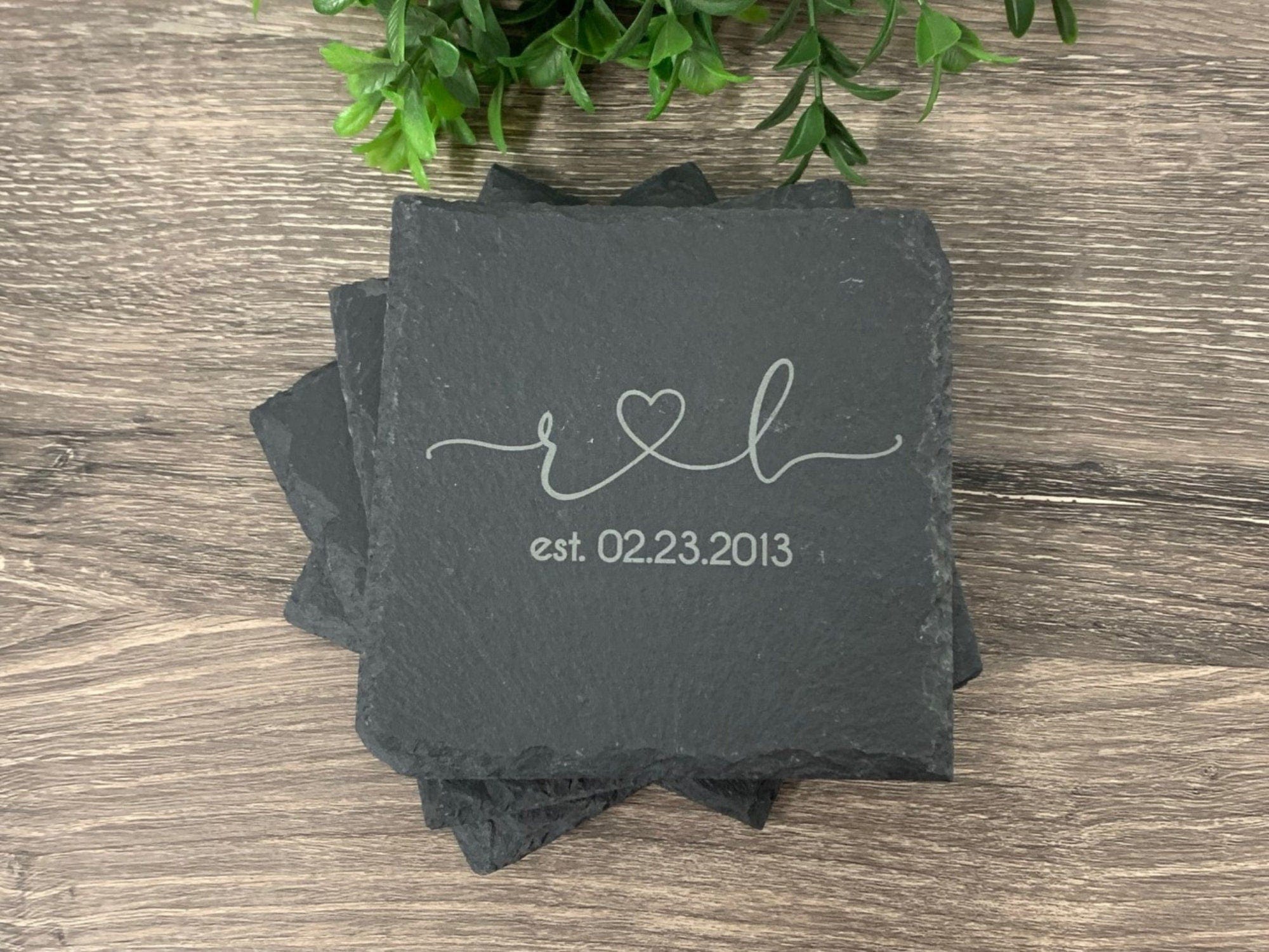 slate coasters laser engraved with two initials joined together with a heart with established date below