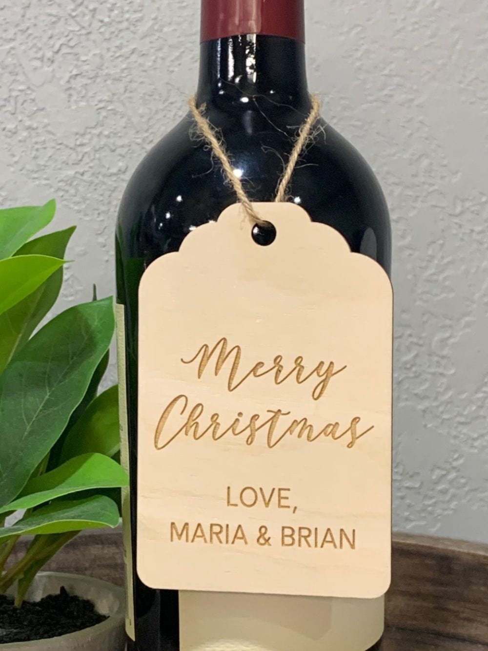 Laser engraved and cut wood Merry Christmas wine bottle tag. Comes personalized with your names or short message. Comes with jute twine.